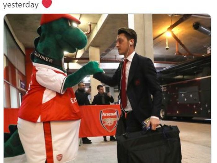 Mesut Oezil saat bersama dengan maskot klub Arsenal, Gunnersaurus.