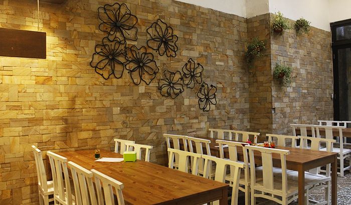 Kepala Manyung Bu Fat boosts gardeny design with wood tables and indoor plants.