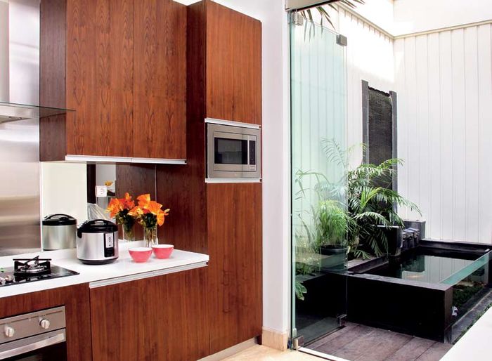 Memasukkan view taman ke dapur modern apik dan elegan gunakan kaca.