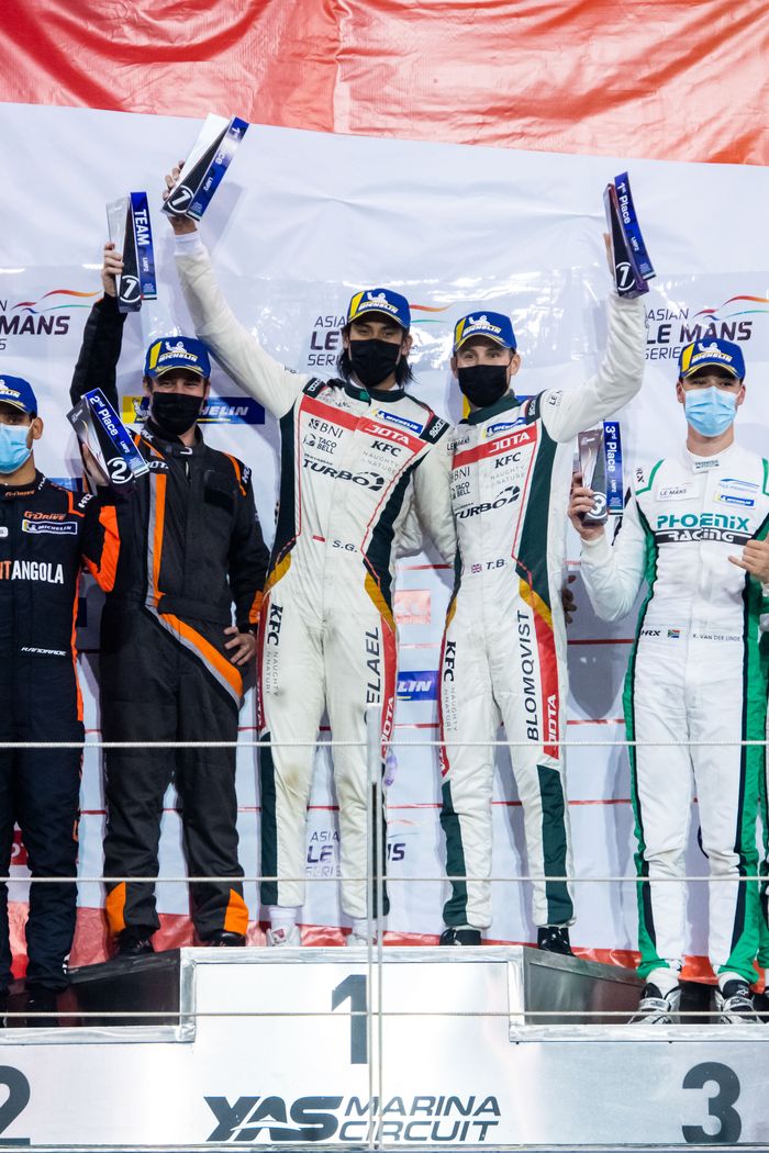 Pembalap Indonesia,  Sean Gelael  kanan) dan pebalap Inggris Tom Blomqvist berpose di podium Sirkuit Yas Marina, Abu Dhabi. Keduanya tampil gemilang untuk menjuarai balapan seri empat Asian Le Mans Series untuk kategori LMP2 dengan bendera tim JOTA Sport, Sabtu (20/2/2021).