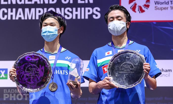 Pasangan ganda putra Jepang, Hiroyuki Endo/Yuta Watanabe, berpose dengan plakat juara All England Open 2021 usai mengalahkan rekan senegara mereka, Takeshi Kamura/Keigo Sonoda, pada laga final di Arena Birmingham, Birmingham, Inggris, Minggu (21/3/2021).