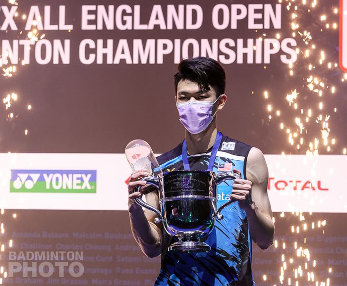 Pebulu tangkis tunggal putra Malaysia, Lee Zii Jia, memegang trofi juara pada All England Open 2021 di Utilita Arena Birmingham, Inggris, Minggu (21/3/2021).