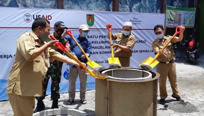 Mukh Ma'ruf (kedua dari kanan) Kepala Desa Pucungrejo, Kecamatan Muntilan, Kabupaten Magelang menuangkan material cor pada cetakan jamban pada peluncuran Pembangunan Jamban Layak Keluarga di Desa Pucungrejo, Selasa (23/3/2021), di Balai Desa Pucungrejo. 