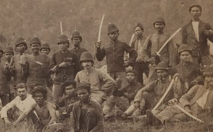 Letnan Satu T.J. Veltman bersama brigade Marechaussee dan porter mereka di Aceh Besar, 1898. Fotografer: C.B. Nieuwenhuis .