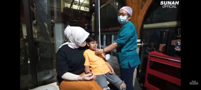 Nathalie temani anak sambungnya di uap dengan nebulaizer.