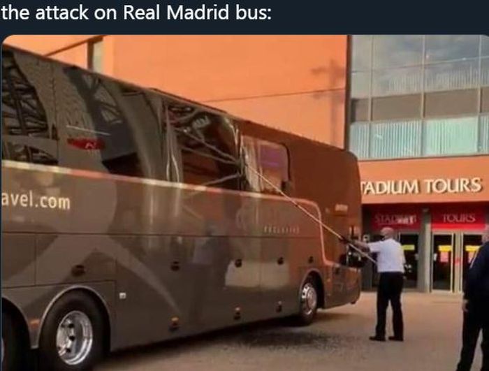 Petugas membersihkan pecahan kaca bus yang mengangkut skuad Real Madrid yang diserang oknum suporter sebelum memasuki kandang Liverpool, Anfield.