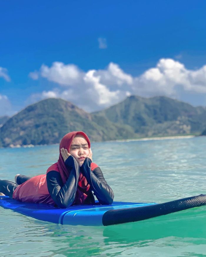 Ria Ricis tampak bahagia di depan dalam perjalanannya di Flores, Nusa Tenggara Timur (NTT).  Namun, sang kakak malah meminta Ria Ricis cepat pulang.