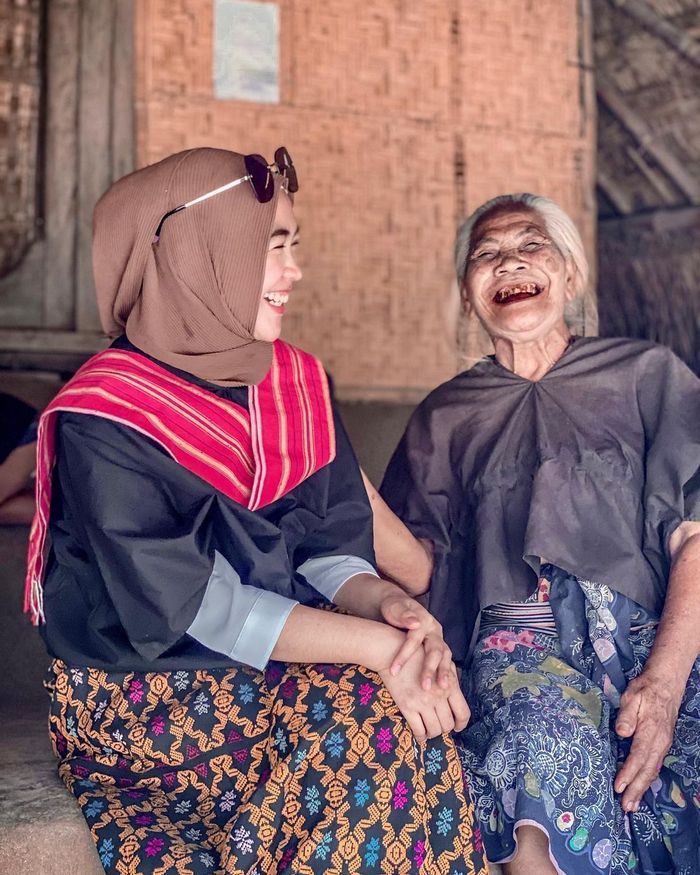 Ria Ricis tampak bahagia di depan dalam perjalanannya di Flores, Nusa Tenggara Timur (NTT).  Namun, sang kakak malah meminta Ria Ricis cepat pulang.