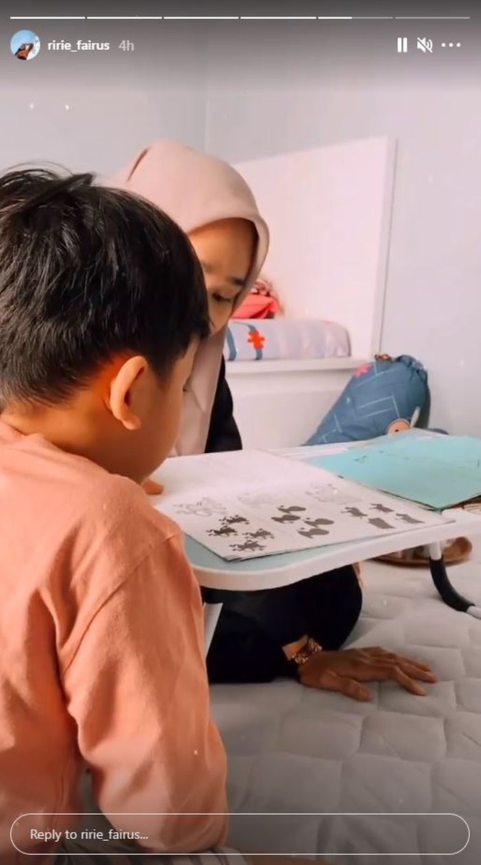 Ririe Fairus terlihat mengajari anaknya belajar.