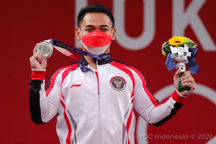 Atlet angkat besi, Eko Yuli Irawan, berpose dengan medali perak yang diraihnya pada lomba nomor 61kg putra Olimpiade Tokyo 2020 di Tokyo International Forum, Jepang, 25 Juli 2021.