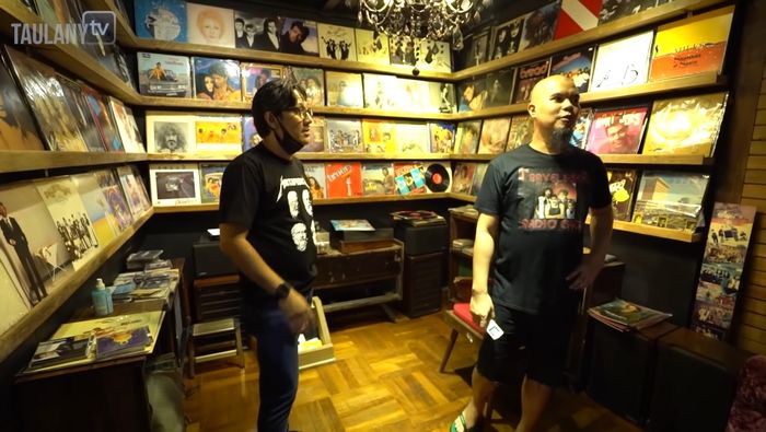 Andre Taulany melihat koleksi piringan hitam di rumah Ahmad Dhani.