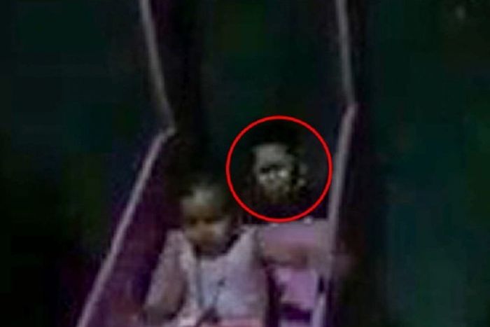 Sosok makhluk menyeramkan muncul di belakang seorang anak kecil yang sedang bermain perosotan