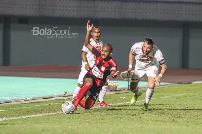 Pemain Persipura Jayapura, Ian Louis Kabes (tengah), sedang bertanding dengan dua pilar Persija Jakarta, Riko Simanjuntak (kiri) dan Marko Simic (kanan), dalam laga pekan ketiga Liga 1 2021 di Stadion Indomilk Arena, Tangerang, Banten, 19 September 2021.