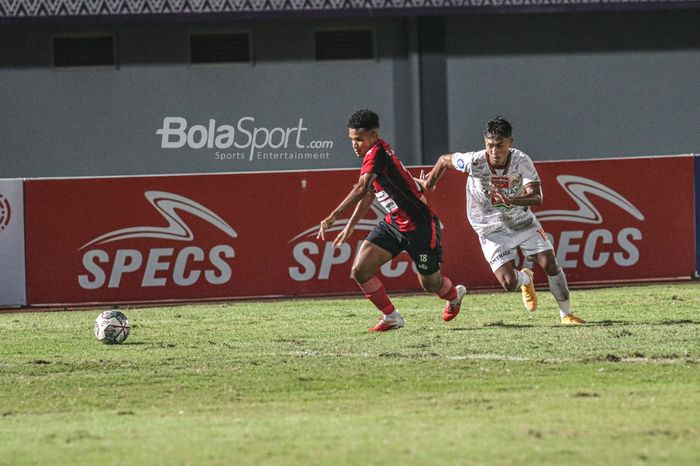 Pemain Persipura Jayapura, David Rumakiek (kiri), sedang mengejar bola dan diikuti pilar Persija Jakarta, Alfriyanto Nico (kanan), dalam laga pekan ketiga Liga 1 2021 di Stadion Indomilk Arena, Tangerang, Banten, 19 September 2021.