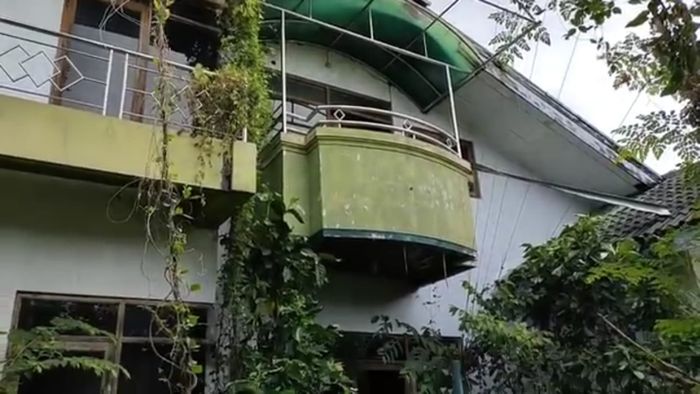 Penampakan rumah dari luar yang ditumbuhi semak belukar.