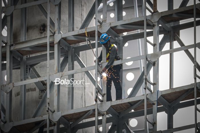 Seorang pekerja sedang melakukan pekerjaannya dalam proses pembangunan Jakarta Internasional Stadium, Papanggo, Jakarta Utara, 7 Desember 2021.