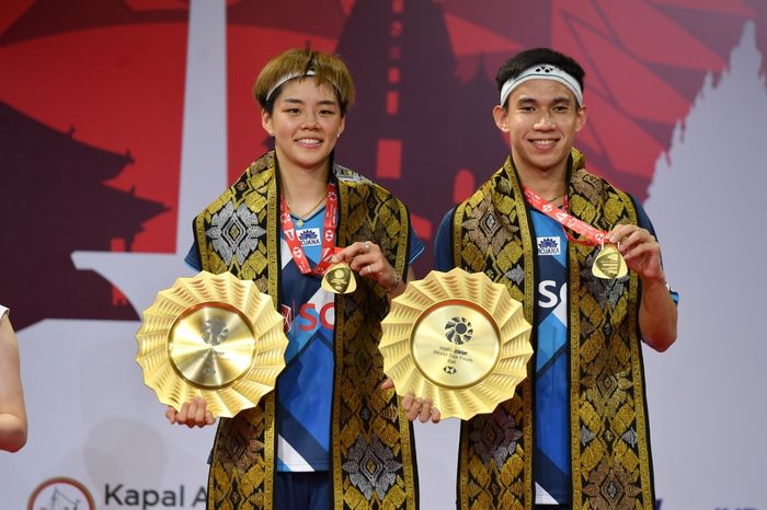 Pasangan ganda campuran Thailand, Dechapol Puavaranukroh/Sapsiree Taerattanachai, berpose setelah menjuarai BWF World Tour Finals 2021 di Bali International Convention Centre, Nusa Dua, Minggu (5/12/2021).