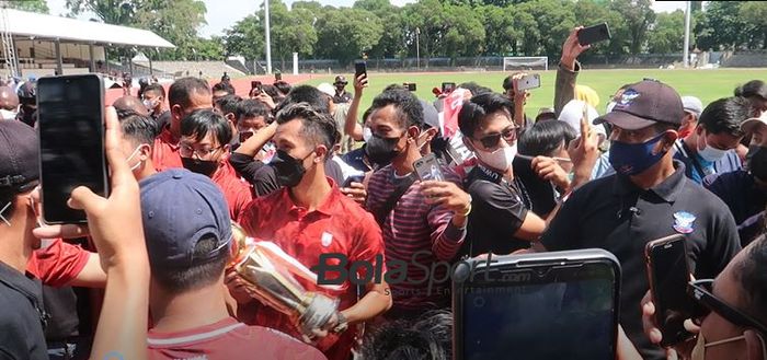 Pemain Persis Solo, Shulton Fajar merayakan juara Liga 2 2021 dengan memamerkan trofi ke suporternya di Stadion Sriwedari, Surakarta, Minggu (9/1/2022).