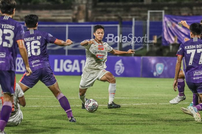 Bek sayap kanan Persija Jakarta, Ilham Rio Fahmi (jersey putih), nampak sedang menguasai bola dalam laga pekan ke-21 Liga 1 2021 di Stadion Gelora Ngurah Rai, Bali, 26 Januari 2022.