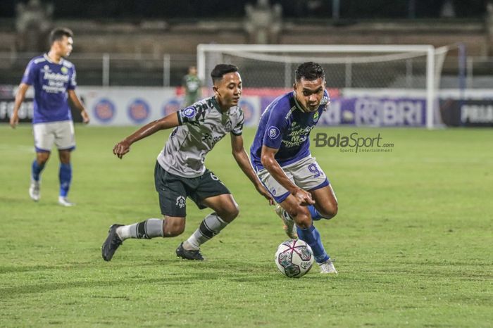 Penyerang Persib Bandung, Erwin Ramdani (kanan), nampak menguasai bola dan dibayangi pemain Tira Persikabo, Roni Sugeng Ariyanto (kiri), dalam laga pekan ke-21 Liga 1 2021 di Stadion Gelora Ngurah Rai, Bali, 29 Januari 2022.