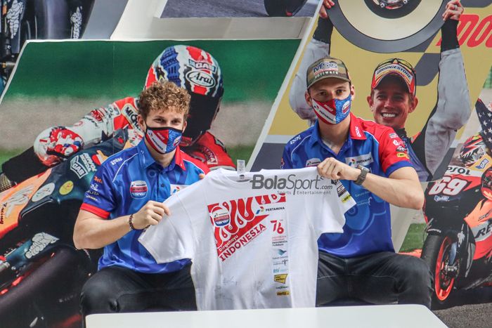 Dua pembalap Mandalika Racing Team Indonesia (Pertamina Mandalika SAG), Bo Bendsneyder (kanan) dan Gabriel Rodrigo (kiri), sedang memperlihatkan baju yang sudah ditandatanganinya di Epicentrum, Kuningan, Jakarta, 10 Maret 2022.