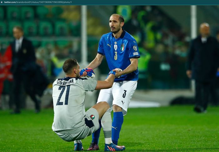 Kiper timnas Italia, Gianluigi Donnarumma tampak berusaha dikuatkan oleh Giorgio Chiellini usai timnya gagal lolos ke Piala Dunia 2022.