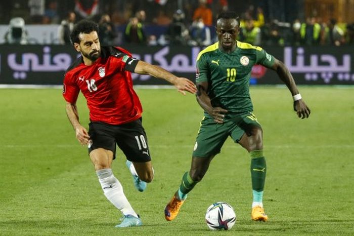 Striker timnas Mesir, Mohamed Salah, berebut bola dengan penyerang timnas Senegal, Sadio Mane, dalam laga putaran ketiga Kualifikasi Piala Dunia 2022 Zona Afrika di Stadion Cairo International, 25 Maret 2022.