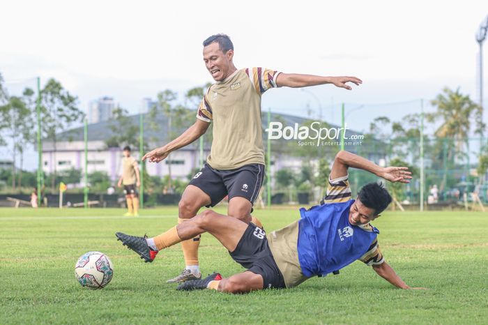 Bek sayap kiri Dewa United, Jajang Sukmara (kiri), sedang menguasai bola dan berusaha dihalau rekannya yakni Suhandi (kanan) dalam sesi latihan di Lapangan Luar Stadion Indomilk Arena, Tangerang, Banten, 6 April 2022.