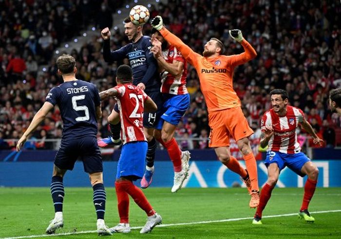 Kiper Atletico Madrid, Jan Oblak, meninju bola dalam duel perebutan dengan pemain Manchester City dalam duel Liga Champions di Wanda Metropolitano, Madrid (13/4/2022).
