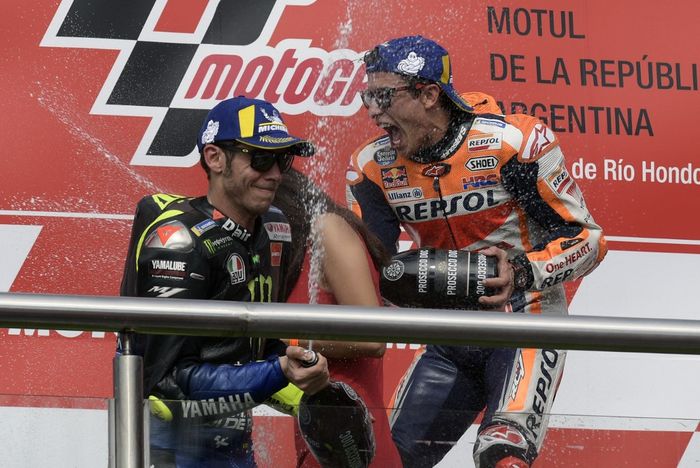 Pemenang balapan, Marc Marquez (Repsol Honda/kiri), dan runner-up, Valentino Rossi (Monster Energy Yamaha),  merayakan hasil mereka di podium setelah MotoGP Argentina di Sirkuit Termas de Rio Hondo, Argentina, 31 Maret 2019.