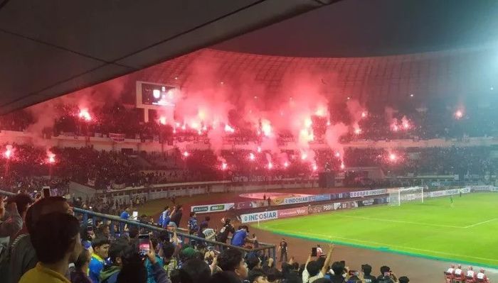 Sejumlah oknum bobotoh menyalakan flare atau suar di tribun utara Stadion Gelora Bandung Lautan Api (GBLA) Kota Bandung, Jawa Barat, Minggu (12/6/2022). 