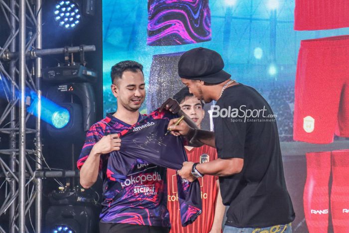 Ronaldinho (kanan) sedang menandatangani jersey RANS Nusantara FC yang ditemani oleh Raffi Ahmad selaku chairman tim di Menara Mandiri, Senayan, Jakarta, 24 Juni 2022.