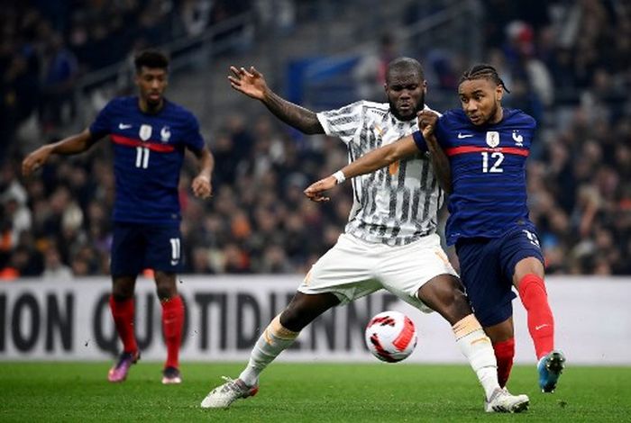 Franck Kessie (kiri) mencoba merebut bola dari Christopher Nkunku dalam duel uji coba timnas Prancis vs Pantai Gading di Marseille (25/3/2022).