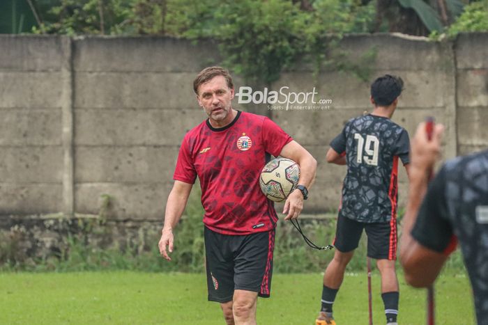 Pelatih Persija Jakarta, Thomas Doll, sedang memegangi bola dan memantau para pemainnya berlatih di Lapangan Nirwana, Sawangan, Jawa Barat , 7 Juli 2022.