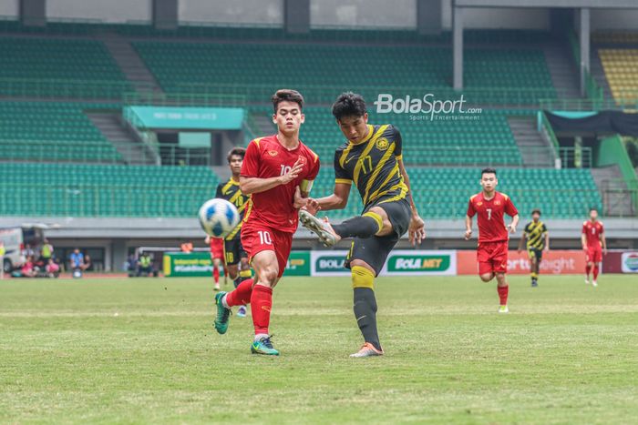 Pemain timnas U-19 Malaysia, Fakrul Fareez Aidi, sedang menyapu bola yang sempat dikuasai pilar timnas U-19 Vietnam bernama Khuat Van Khang (kanan) di Stadion Patriot Candrabhaga, Bekasi, Jawa Barat, 13 Juli 2022.