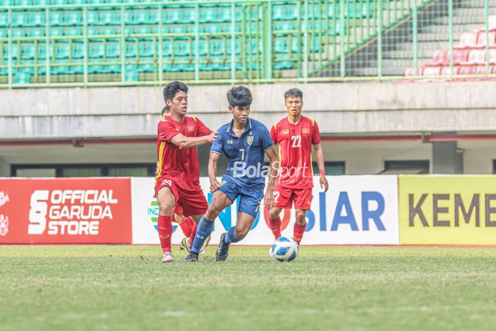 Pemain timnas U-19 Thailand, Kakana Khamyok (tengah), sedang menguasai bola dan dijaga ketat oleh pilar timnas U-19 Vietnam bernama Nguyen Duc Viet (kiri) di Stadion Patriot Candrabhaga, Bekasi, Jawa Barat, 15 Juli 2022.