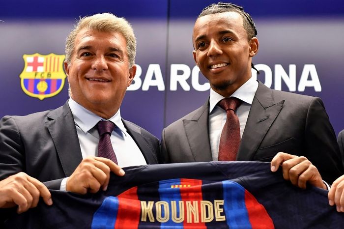 Presiden Barcelona, Joan Laporta (kiri), saat mengesahkan transfer Jules Kounde. Kounde termasuk salah satu calon korban kebutuhan Barca demi mendapatkan pemain baru.