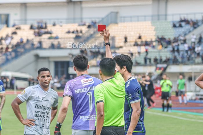 Wasit yang memimpin laga pekan keenam BRI Liga 1-2022/2023 antara Persib Bandung versus Bali United, M. Erfan Efendi (kanan), memberikan kartu merah kepada Nadeo Argawinata (jersey ungu)