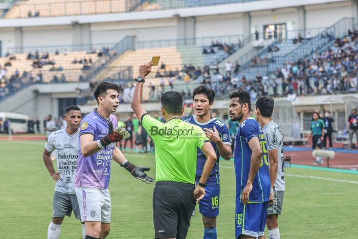 Wasit sedang memberikan kartu kuning kepada kiper Bali United bernama Nadeo Argawinata dalam laga pekan kenam Liga 1 2022 di Stadion Gelora Bandung Lautan Api, Bandung, Jawa Barat, 23 Agustus 2022.