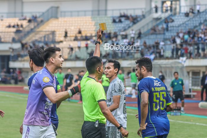 Wasit sedang memberikan kartu kuning kepada gelandang Persib Bandung bernama Ricky Kambuaya (kanan) dalam laga   pekan keenam BRI Liga 1-2022/2023 di Stadion Gelora Bandung Lautan Api, Bandung, Jawa Barat, 23 Agustus 2022.