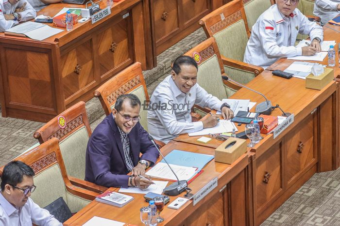 Menteri Pemuda dan Olahraga Republik Indonesia, Zainudin Amali (kanan) dan Wakil Kementerian Hukum dan HAM, Edward Omar Sharif Hiariej (kiri), nampak sumringah saat mengikuti rapat di Gedung DPR RI, Jakarta, 29 Agustus 2022.