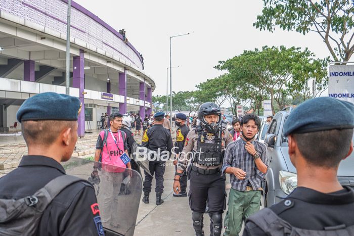 Polisi nampak mengamankan salah satu oknum suporter yang sempat mericuhi seusai laga Persita versus PSIS Semarang di Stadion Indomilk Arena, Tangerang, Banten, 14 September 2022.