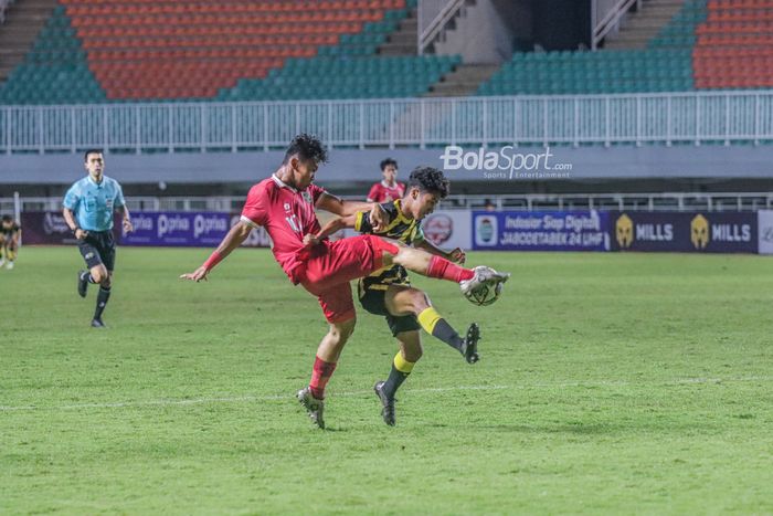 Pemain timnas U-17 Indonesia, Muhammad Nabil Asyura (kiri), sedang berebut bola yang dikuasai pilae timnas U-17 Malaysia bernama Muhammad Danish Darus (kanan) dalam laga Kualifikasi Piala Asia U-17 2023 di Stadion Pakansari, Bogor, Jawa Barat, 9 Oktober 2022.