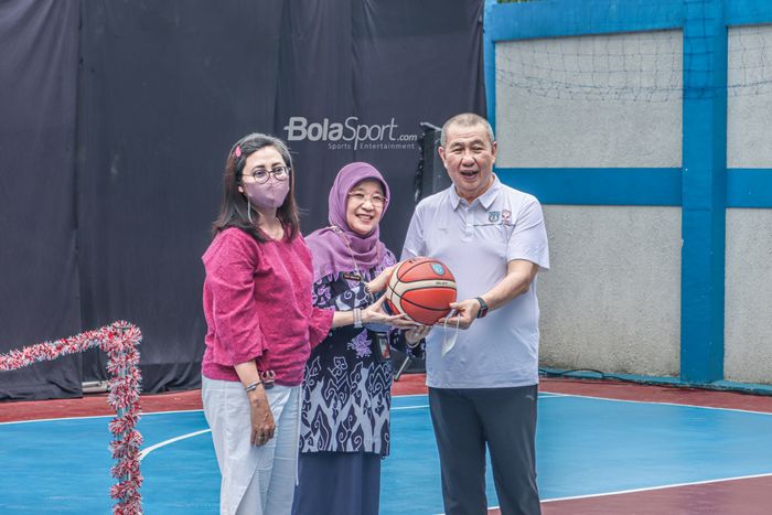Ketua Perbasi, Denny Kosasih (kanan), tampak memberikan bantuan dengan simbolis hadiah bola basket ke Kepala Sekolah SMP 74 Jakarta bernama Enny Mulyani (tengah).