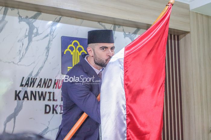 Jordi Amat tampak sedang mencium bendera merah putih seusai menjalani pengambilan sumpah setia kewarganegaraan di Kantor Wilayah Kemenkumham, Cawang, Jakarta, 17 November 2022.