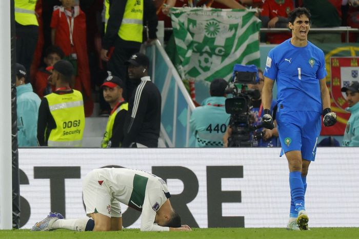 Kiper timnas Maroko, Yassine Bounou, melakukan selebrasi ketika kapten timnas Portugal, Cristiano Ronaldo, tertunduk lesu dalam laga perempat final Piala Dunia 2022 di Stadion Education City, Sabtu (10/12/2022).