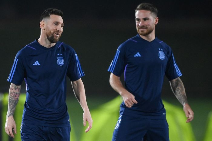 Kapten timnas Argentina, Lionel Messi, berbincang dengan Alexis Mac Allister dalam sesi latihan di Qatar University, Sabtu (17/12/2022).