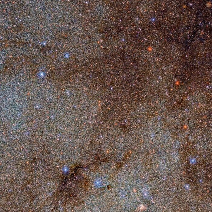Dipenuhi dengan awan gelap bintang dan debu, gambar ini adalah snapshot kecil – sebuah tusukan jarum – dari seluruh Survei Pesawat Kamera Energi Gelap Bima Sakti (DECaPS2).