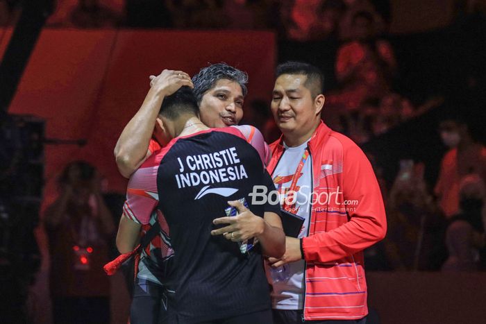 Pebulu tangkis tunggal putra Indonesia, Jonatan Christie, memeluk pelatihnya, Irwansyah, setelah mengalahkan Shi Yu Qi (China) pada semifinal Indonesia Masters 2023 di Istora Senayan, Jakarta, Sabtu (28/1/2023).