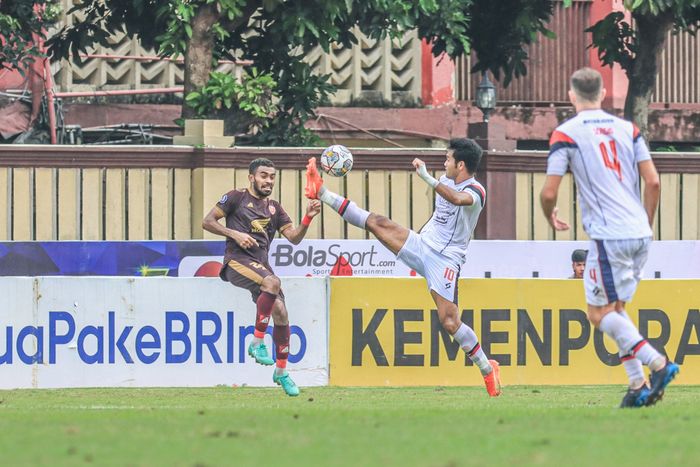 Striker Arema FC, Muhammad Rafli (kanan), sedang menjangkau bola dan dijaga ketat oleh pemain PSM Makassar bernama Yakob Sayuri (kiri) dalam laga pekan ke-22 Liga 1 2022 di Stadion PTIK, Jakarta, 4 Februari 2023.